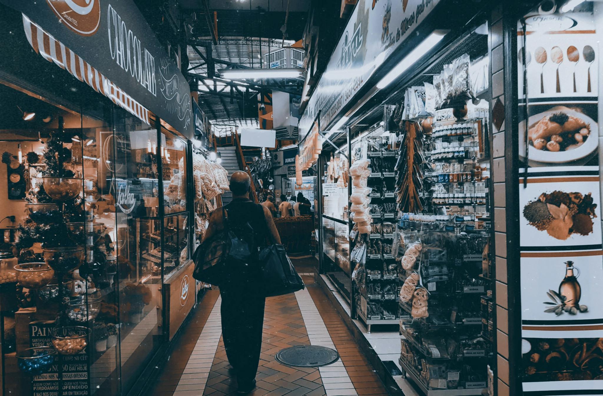 A lively urban indoor market with shops, products, and people shopping.
